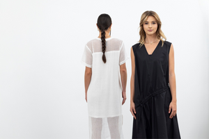 Two women wearing a white dress and a black dress on a white background